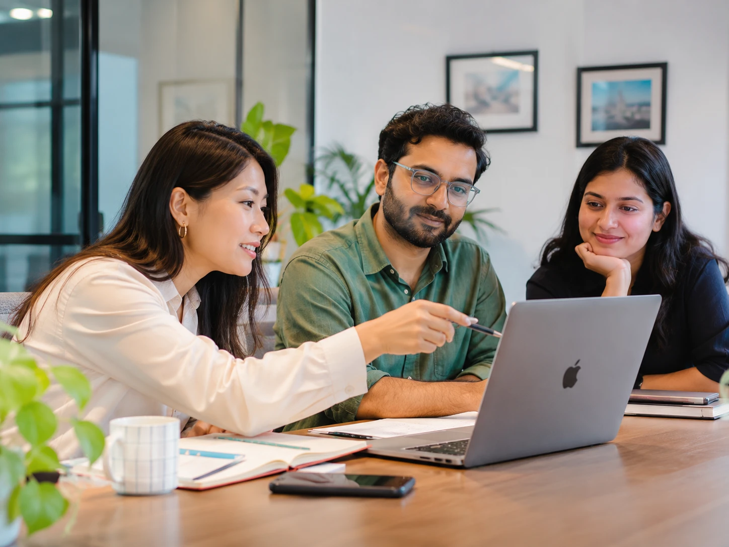 Three Masterclass Space colleagues reviewing work together at a laptop